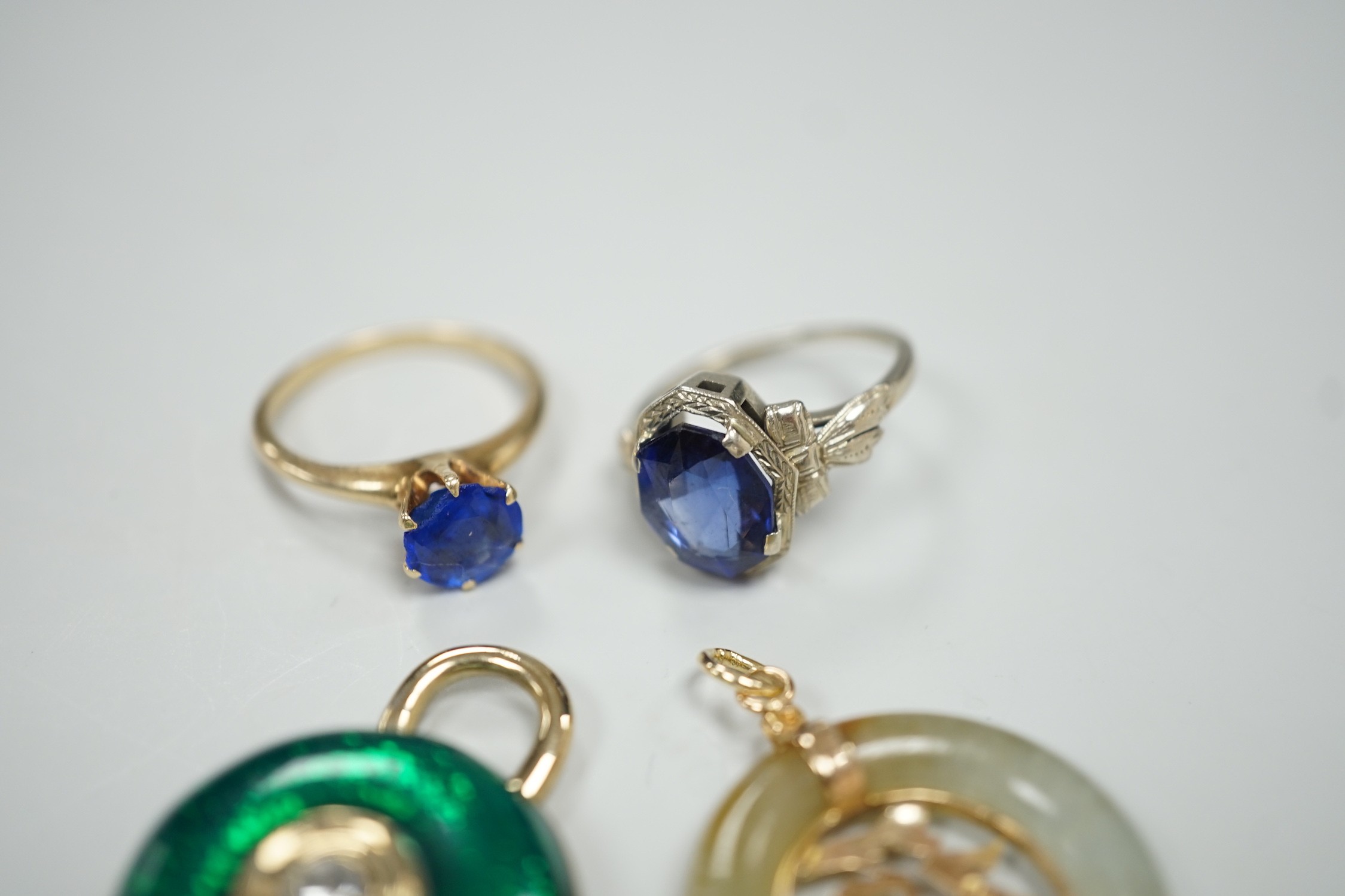 A 14k white metal and oval cut synthetic sapphire ring, a yellow metal and blue paste ring, a 585 yellow metal and jadeite pendant and a costume pendant.